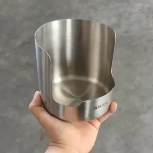 Stainless steel pot lid holder keeping a glass pot lid and spatula upright on a tidy kitchen counter